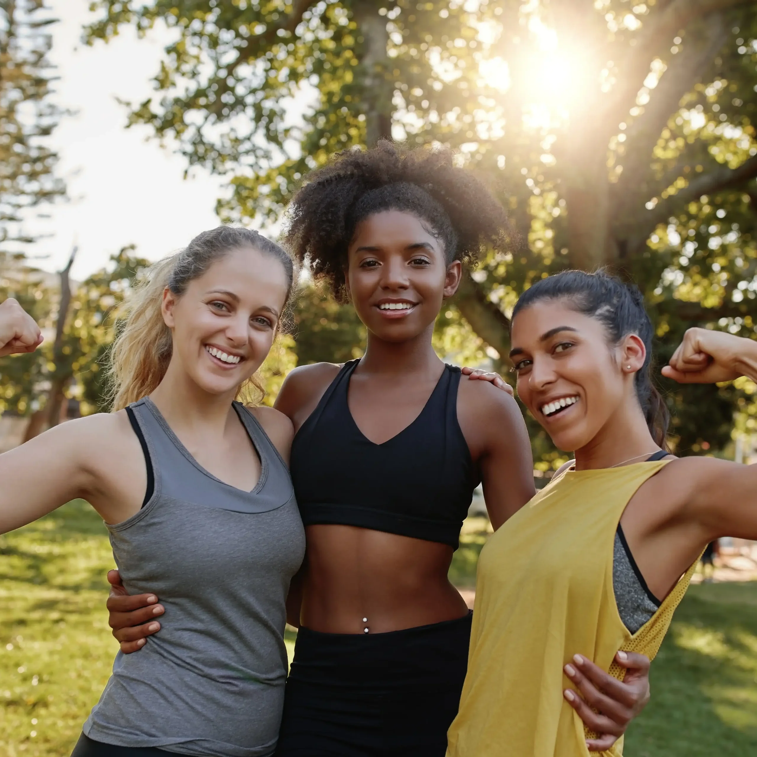 trio of three athletic friends posing after a run together