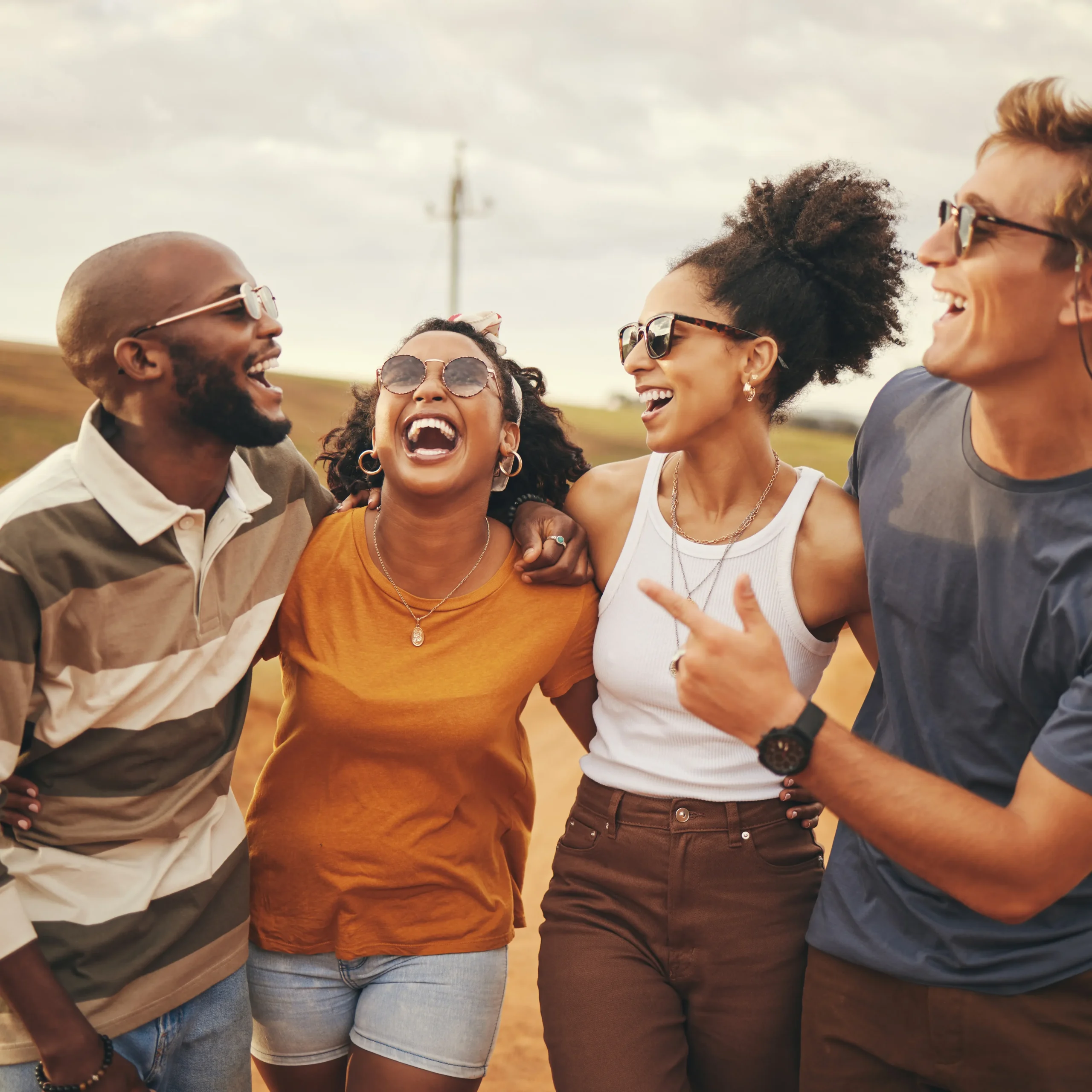 group of friends smiling and laughing while they walk outside together