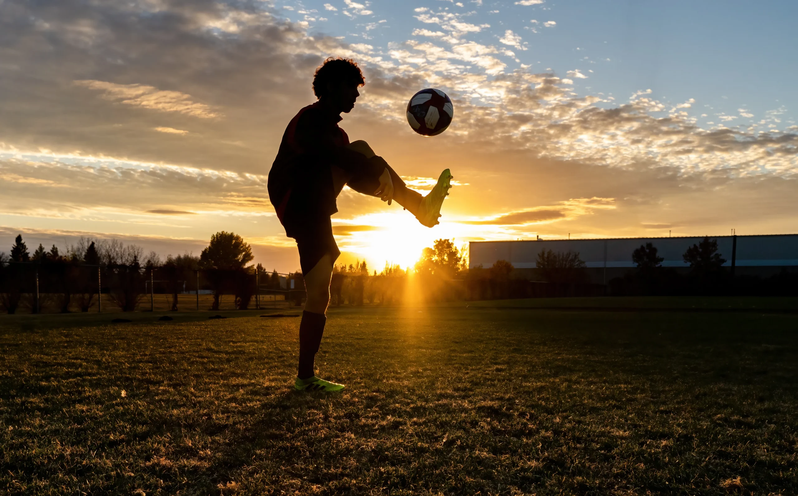 athlete kicking a soccer ball up to improve dexterity and coordination for the fall sport season