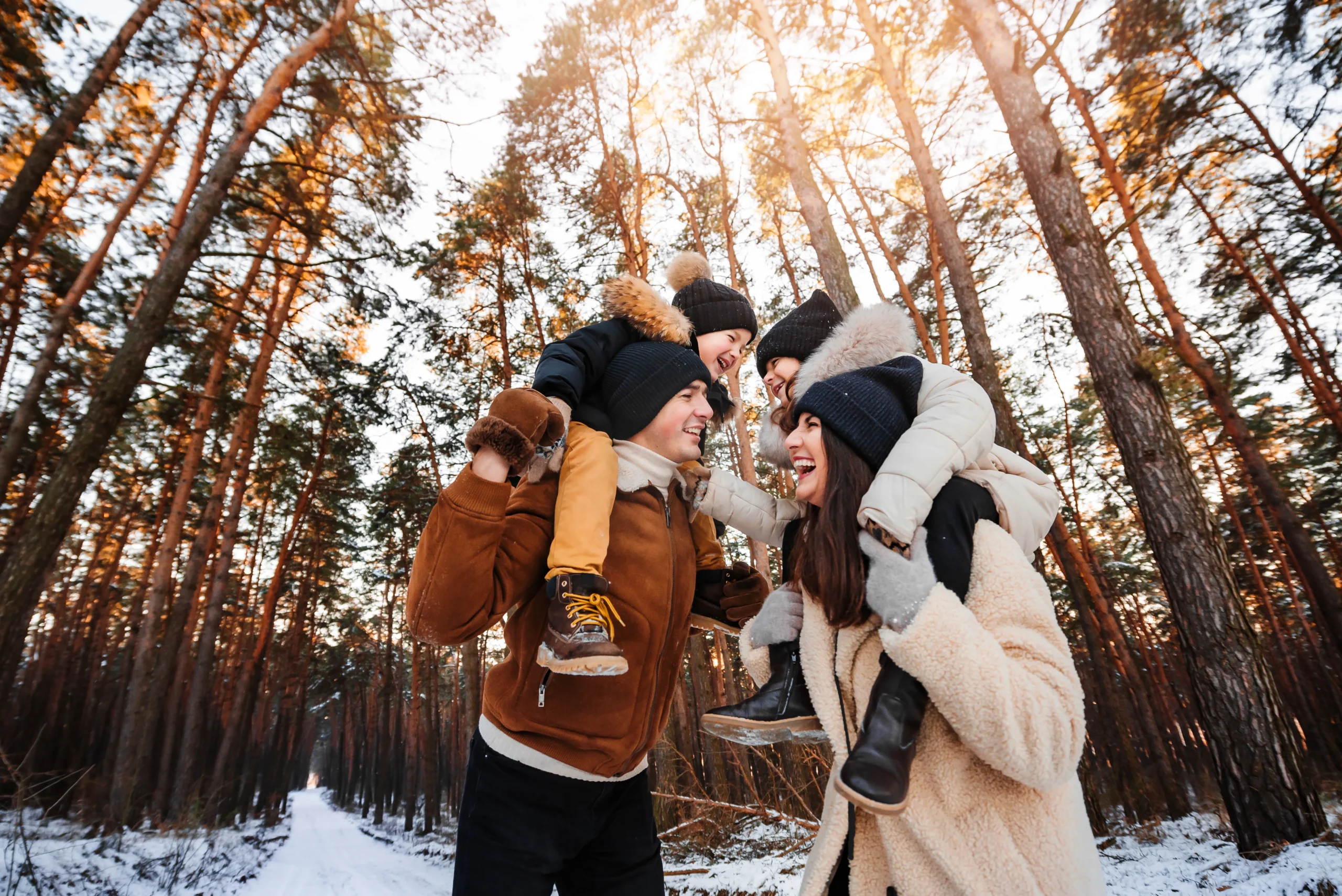 mother and father using their core strength to safely carrying their children on their shoulders in the woods