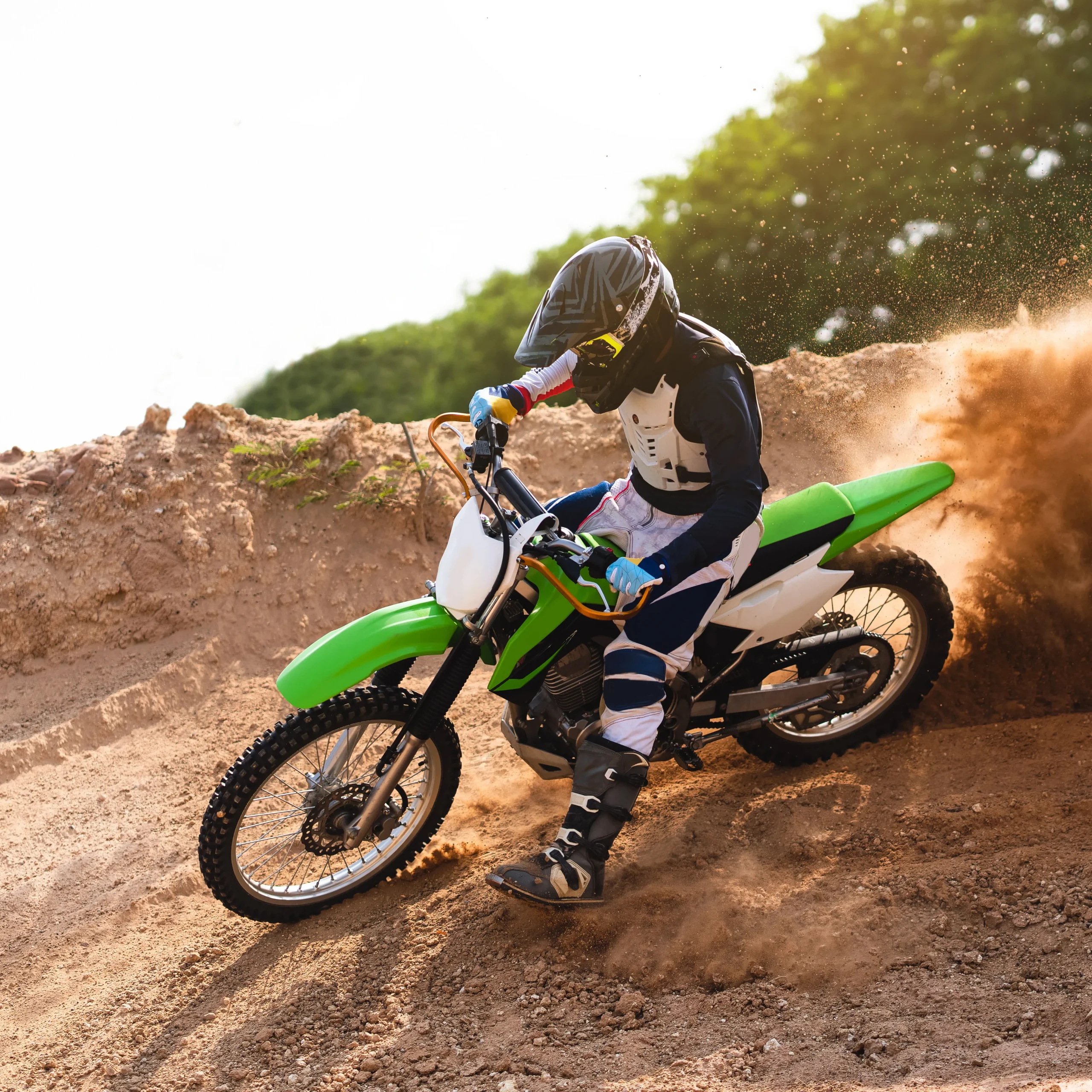 person riding a dirt bike and holding out their foot to brake